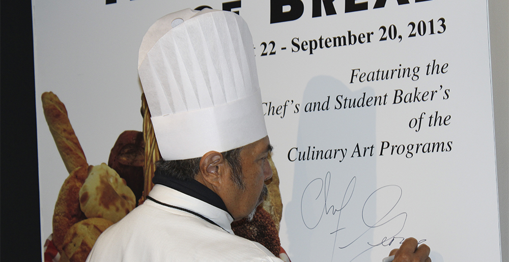 Photo of Chef Tucker signing artwork