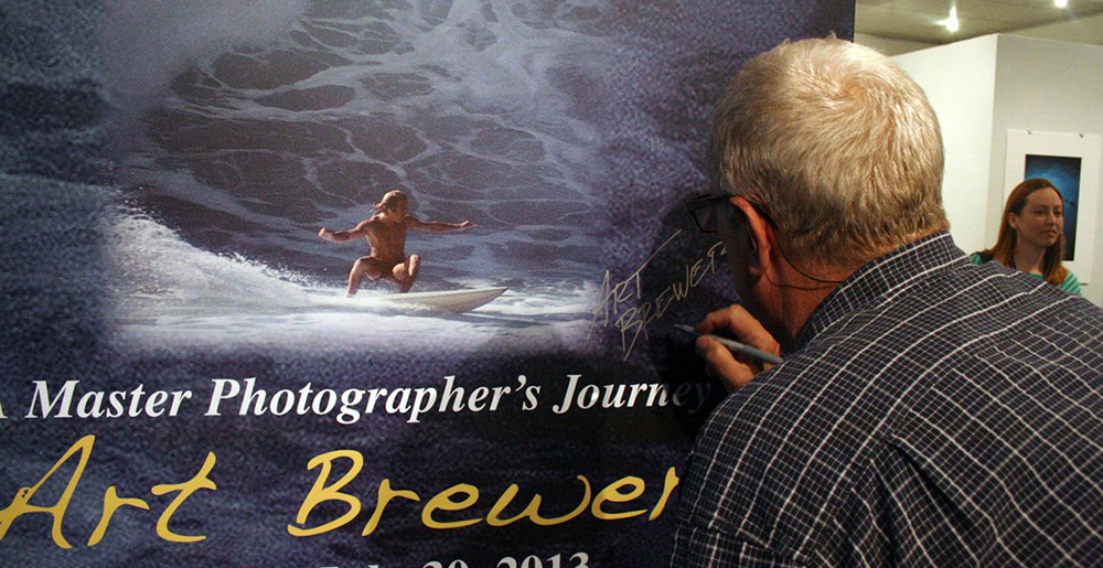 Photo of Brewer signing artwork