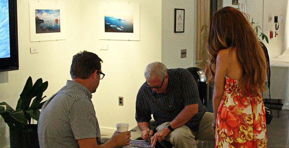 Photo of Brewer signing artwork